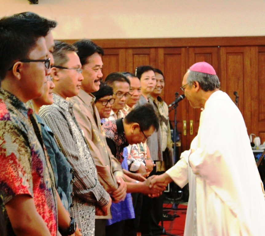  Ketua Umum Presidium Pusat Ikatan Sarjana Katolik Indonesia (ISKA), Hargo Mandirahardjo bersalaman dengan Uskup Agung Samarinda, Mgr. Y. Hardjosusanto MSF, dalam suatu acara. 